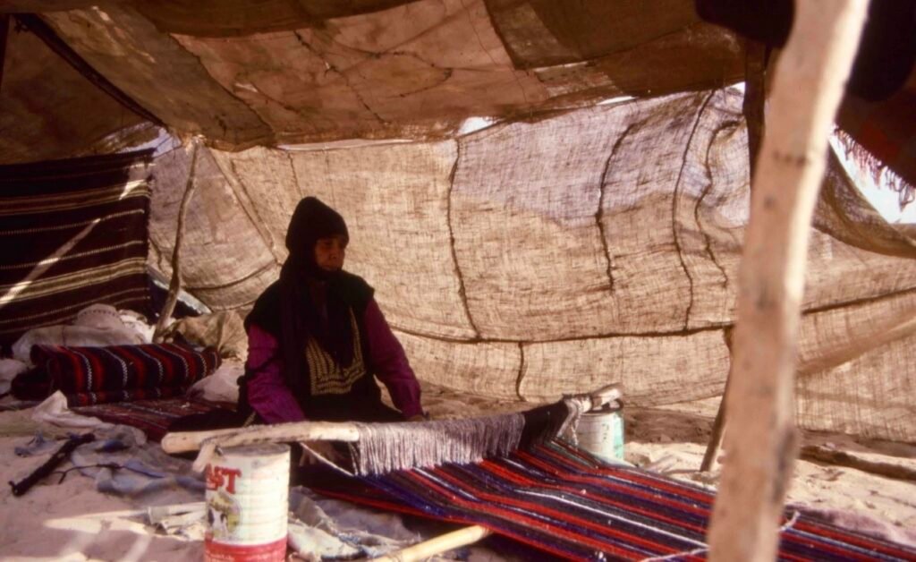 A Bedouin woman weaving goat hair to make the traditional Bedouin tent (Beit Al-Sha’ar) in Wadi Rum.