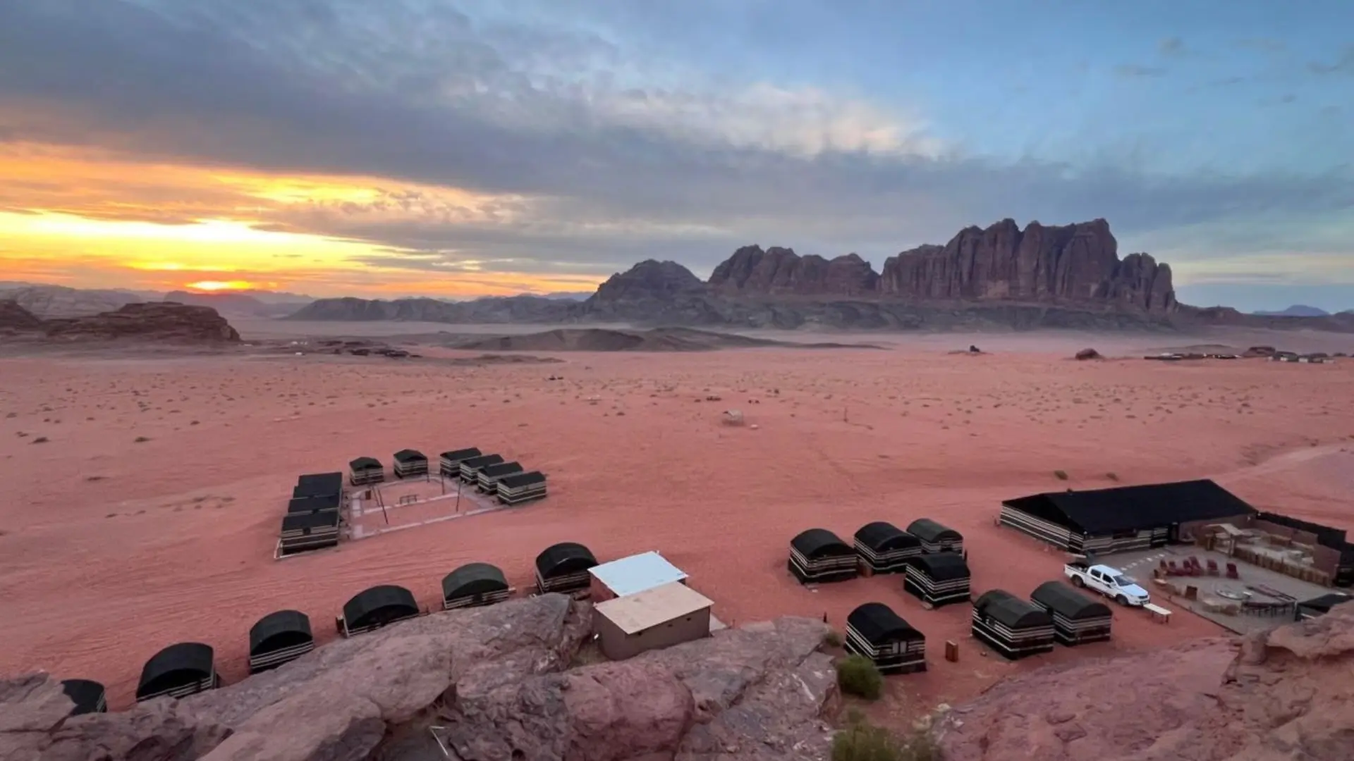 Bedouin tents surrounded by red sand and sandstone mountains in Wadi Rum